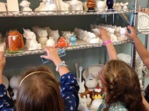 Children choosing pottery to paint