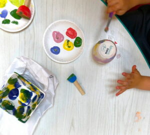 Children painting pottery from a pallette of colors